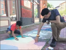  ?? GLENN GRIFFITH -MEDIANEWS GROUP FILE ?? Cameron Geary, 10, and his brother Donye Geary, 14, work on their sidewalk chalk entries at the 2019Troy River Fest.