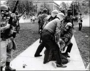  ?? THE COLUMBUS DISPATCH ?? Tear gas is used to clear theOhio State Oval as police officers and guardsmen arrest a student inMay 1970.