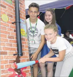  ??  ?? Izzy Dowsett, 10, strikes it lucky on the rat down a drainpipe game, with organisers Holly Copley and Thomas Green, both 16; Tia Borke, six, created this sand picture