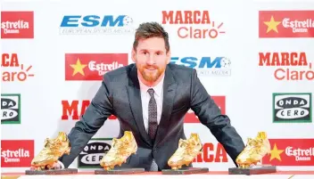  ?? — AFP photo ?? Barcelona's Argentinia­n forward Lionel Messi poses with his four Golden Shoe awards after receiving the 2017 European Golden Shoe honoring the year's leading goalscorer during a ceremony at the Antigua Fabrica Estrella Damm in Barcelona on November 24,...