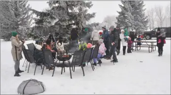  ?? ?? World Snow Day participan­ts enjoy the warmth of a fire pit while roasting hot dogs.