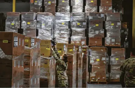  ?? Photos by Kin Man Hui / Staff photograph­er ?? Texas National Guard personnel work with boxes of personal protective equipment Tuesday as Gov. Greg Abbott and other state officials visit a Texas Division of Emergency Management warehouse in San Antonio.