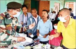  ?? PTI ?? People receive medicines at a health camp organised by the Assam Rifles for health check-up and aware people about coronaviru­s, in Dharmanaga­r, Tripura on Saturday