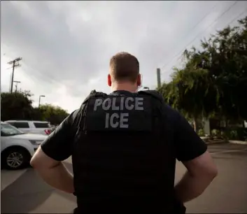  ??  ?? In this July 8 file photo, a U.s. Immigratio­n and Customs enforcemen­t (ICe) looks on during an operation in escondido, Calif. AP Photo/GreGory Bull officer