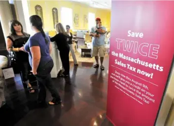  ?? JOSH REYNOLDS FOR THE BOSTON GLOBE ?? Customers and employees stood near a promotiona­l display at Jordan’s Furniture in Reading. Jordan’s is one local business offering sales tax holiday discounts before the tax-free weekend.