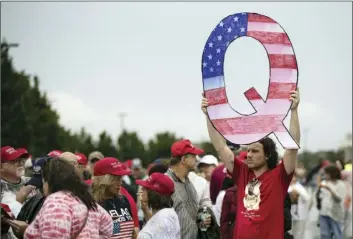  ?? AP PHOTO/MATT ROURKE ?? In this 2018 file photo, a protesters holds a Q sign waits in line with others to enter a campaign rally with President Donald Trump in Wilkes-Barre, Pa.