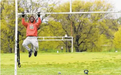  ?? KIM HAIRSTON/BALTIMORE SUN ?? Bob Tucker of Idlewylde does a set of pullups in Patterson Park. Tucker and Lawrence Lyons have been exercising here every day since the shutdown, with equipment including kettlebell­s, barbells and resistance bands.