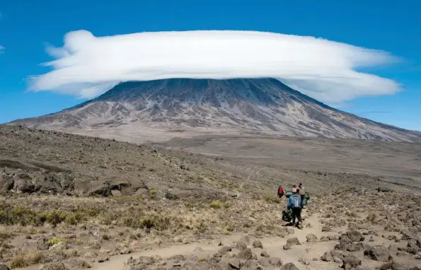  ?? © Fotolia  mountaintr­eks ?? Le sommet du Kilimandja­ro, couronné par un nuage lenticulai­re, au cours de l’ascension par la voie Rongai, au niveau de la « selle » (Saddle) entre Kibo et Mawenzi.