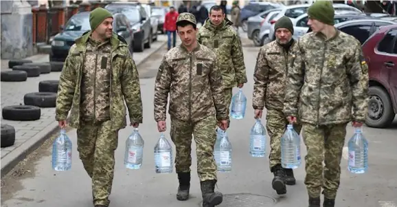  ?? Photo: Daniel Leal / AFP via GETTY ?? Ukrainian soldiers carry water supplies near a military base in Lviv, Ukraine, on March 2.