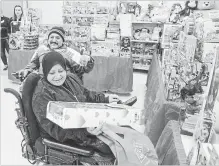  ?? SCOTT GARDNER THE HAMILTON SPECTATOR ?? Hayat Mohammed chooses a toy for her son as husband Waleed Taher looks on. During the holiday season, the centre will serve 2, 418 area families . The operation depends on the services of its many volunteers.