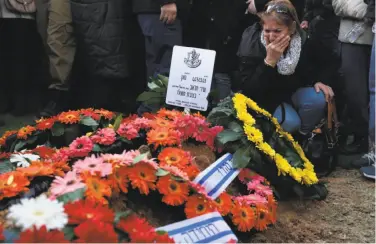  ?? Menahem Kahana / AFP / Getty Images ?? A relative of Israeli soldier Shir Hajaj, 22, mourns over her grave at a military cemetery in Jerusalem.