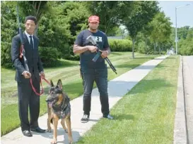  ?? JEFFREY F. BILL/BALTIMORE SUN MEDIA ?? J’Den McAdory, right, carries a Radical Firearms RF15 rifle, and Michal Deangelo Billups, stands with his dog “General” and carries a Remington 870.