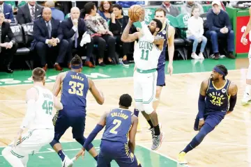  ??  ?? Kyrie Irving (third left) takes a shot while defended by Indiana Pacers guard Darren Collison (centre) and centre Myles Turner during the first half in game two of the first round of the 2019 NBA Playoffs at TD Garden. — USA TODAY Sports photo