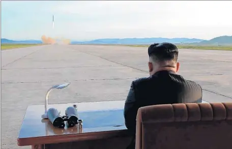  ?? AFP/Getty Images ?? KIM JONG UN watches a missile launching drill. By the end of 2017, Kim had changed the U.S. perception of his nuclear force.