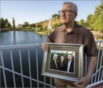  ?? AP PHOTO ?? In this June 23 photo, Frank Kerrigan holds onto a photograph of his three children John, Carole, and Frank, near Wildomar.