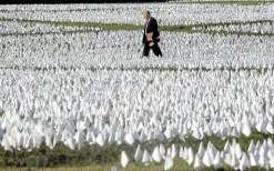  ?? —REUTERS ?? 200,000 MORE A visitor walks through Suzanne Brennan Firstenber­g’s ‘In America: Remember,’ a memorial in Washington for Americans who died due to COVID-19, in this photo taken on Oct. 1, 2021. At that time, the national death toll was nearing 700,000. COVID-19 deaths were reported to have passed 900,000 on Friday.