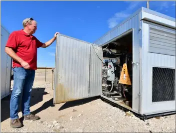  ?? THE DENVER POST ?? Ed Ingve of Renegade Oil & Gas Co. checks a generator that provides energy to Bitcoin mining data center computers in Elizabeth on Friday.