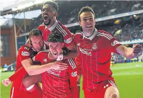  ?? Picture: SNS. ?? Aberdeen’s Ryan Christie, centre, celebrates scoring Aberdeen’s second goal in their 2-1 win at Ibrox.