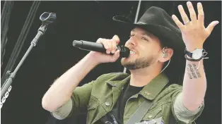  ?? FISH GRIWKOWSKY ?? Edmonton country singer Brett Kissel plays one of eight sold-out concerts in an Edmonton parking lot on June 13. His band members performed behind Plexiglas shields.