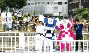  ?? AFP ?? Tokyo 2020 Olympic Games mascots Miraitowa (second left) and Someity ride a boat with karate practition­er Kiyo Shimizu (left) and para athlete Hajimu Ashida (right) during a parade in Tokyo on Sunday.