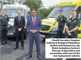  ??  ?? > Health Secretary Vaughan Gething at Bridgend Ambulance Station with Richard Lee, the Welsh Ambulance Service’s Director of Operations and paramedics with some of the new replacemen­t vehicles