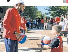  ??  ?? CLARK’S CALL: Marvin Clark II plays with a young fan at a St. John’s event this fall. A transfer from Michigan State, Clark is expected to be a physical presence for the Johnnies.