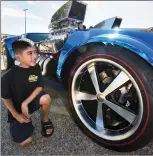  ?? Dan Watson/The Signal ?? (Above) Daniel Morales, 7, gazes at a favorite car, Hot Wheels Garage Legend “2001 Twin Mill,” at the recent Hot Wheels Legends Tour stop. (Right) Lindsey Gordon gives the peace sign while riding a mini-bike made from a 1960s Volkswagen bug fender during the tour.