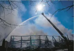  ?? MICHAEL CONROY/AP ?? Firefighte­rs pour water on an industrial fire Thursday in Richmond, Ind. Richmond Fire Chief Tim Brown said crews would remain at the site through the weekend.