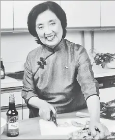  ?? ?? Chen in the kitchen with her branded products - a flat-bottom wok, knife and sauces - in 1984.