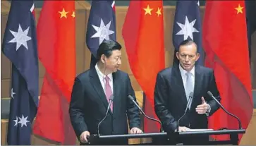  ?? Rick Rycroft Associated Press ?? CHINESE President Xi Jinping, left, and then- Australian Prime Minister Tony Abbott speak in 2014 in Canberra, Australia, as memorandum­s of understand­ing were signed to strengthen trade between the nations.