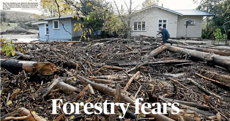  ?? MARTIN DE RUYTER/STUFF ?? Ron Tye clambers over debris in the backyard of the Tapawera-Baton Rd property belonging to Clare James's brother following a storm in May 2010.