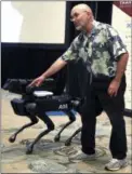  ?? CHARLES KRUPA — THE ASSOCIATED PRESS ?? Boston Dynamics founder Marc Raibert shows the SpotMini robot during a robotics summit in Boston.