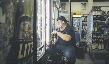  ?? Picture: Jacques Nelles ?? STOCK UP
A worker at the Lyttleton Liquor store repacking the fridge after the alcohol ban was lifted yesterday as the country enters Level 3 of the national lockdown.
