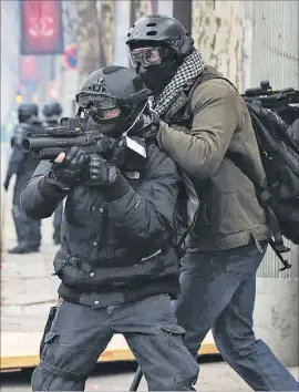  ?? AFP / ZAKARIA ABDELKAFI ?? Dos agentes, ayer, en plena batalla campal en los Campos Elíseos.