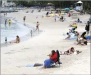  ?? AP file photo ?? People sit on Waikiki Beach in Honolulu last month. Hawaii officials are facing pressure to increase COVID-19 testing for travelers.