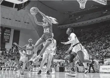  ?? Darron Cummings/Associated Press ?? Miami's Haley Cavinder, left, grabs a rebound against Oklahoma State's Naomie Alnatas in the first half.