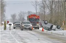  ?? [DAMON MACLEAN] ?? A Woolwich firefighte­r directs traffic on Crowsfoot Road where a driver lost control of their vehicle Feb. 27. No one was injured.