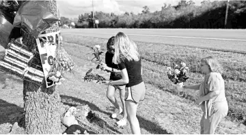  ??  ?? Residents bring memorial items to Santa Fe High School. — AFP photo