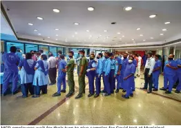  ?? — PTI ?? MCD employees wait for their turn to give samples for Covid test at Municipal Corporatio­n in New Delhi on Friday.
