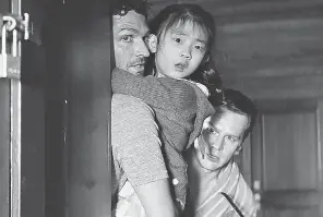  ?? PROVIDED BY UNIVERSAL PICTURES ?? A family ( Ben Aldridge, left, Kristen Cui and Jonathan Groff) faces a group of strangers with weapons in “Knock at the Cabin.”
