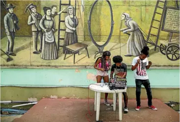  ??  ?? Members of the hip-hop group Nuevo Mundo use a laptop to play American dance music at the Jardines del Mella, Havana, Cuba.