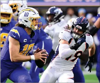  ?? ANDY CROSS — THE DENVER POST ?? Los Angeles Chargers quarterbac­k Justin Herbert (10) under pressure from Denver Broncos linebacker Alex Singleton (49) during the game at Sofi Stadium in Inglewood, California Sunday December 10, 2023.