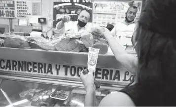  ?? FERNANDO LLANO AP ?? A customer buys meat at Medellin Market in Mexico City recently. Inflation in Mexico accelerate­d in April, bringing the annual rate to 7.68 percent, the highest in two decades.