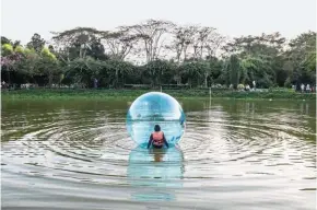  ??  ?? Qui a fianco, svaghi del fine settimana a People’s Park, nel centro di Yangon. Sotto, miniatura di un palazzo in costruzion­e.