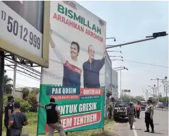  ?? LUDRY PRAYOGA/JAWA POS ?? MASUK KAMPANYE: Petugas satpol PP bersama tim Bawaslu Gresik menertibka­n APK dua pasangan calon bupati-wakil bupati Gresik yang akan berkompeti­si di pilkada 2020. Yakni, pasangan Moh. Qosim-Asluchul Alif dan Fandi Akhmad Yani-Aminatun Habibah.