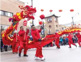  ?? ANTHONY VAZQUEZ/SUN-TIMES PHOTOS ?? BELOW LEFT: Performers as a Chinese dragon make their way down the street Sunday.