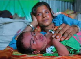  ??  ?? Manju Bauri rests with her newborn baby boy ‘Lockdown’ in their temporary home in northeast India.