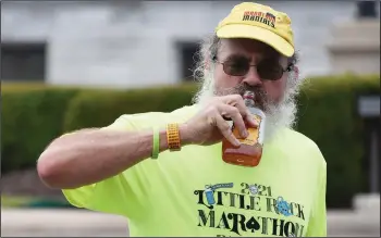  ?? (Arkansas Democrat-Gazette/Staci Vandagriff) ?? Charles Redditt of Conway takes a drink of whiskey during the 15th mile of his race in the Little Rock Marathon on Sunday. Redditt finished the race in a time of 4 hours, 29 minutes and 34 seconds.
