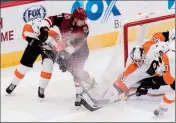  ?? ASSOCIATED PRESS ?? ARIZONA COYOTES’ Brendan Perlini (11) and the Philadelph­ia Flyers’ Ivan Provorov (9) and goalie Calvin Pickard (33) fight for the puck during the second period of Monday’s game in Glendale.