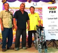  ??  ?? Shamsudin (right) hands over the wheelchair to Haryati’s husband Mohd Sulaiman Abdullah (centre) during ‘Program Bantuan Kasih’ at Kampung Paya Mebi. At left is Padawan Municipal Council councillor Wadel Boyod.